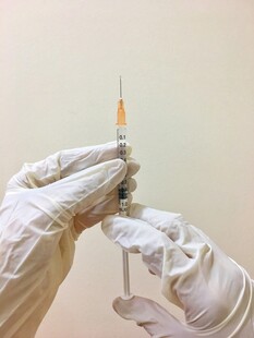 医护人员手持注射器操作