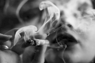 手持香烟冒出袅袅烟雾