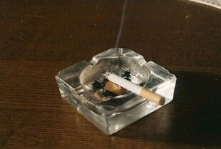 透明烟灰缸中燃着香烟