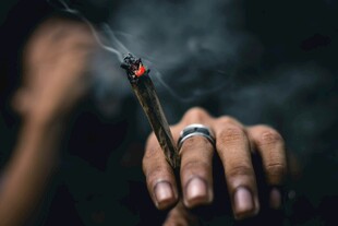 手持点燃香烟的手部特写