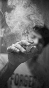 男子手持香烟烟雾缭绕