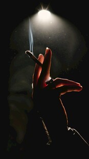 黑暗中手与香烟的光影