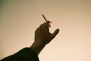手擎香烟于逆光中