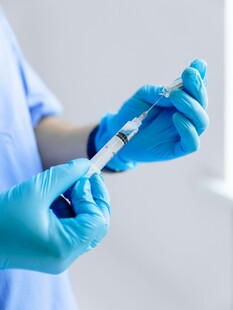 医护人员手持注射器准备注射