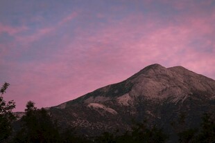 粉霞笼罩下的巍峨山峰