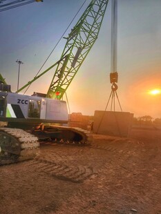 夕阳下的工地起重机作业