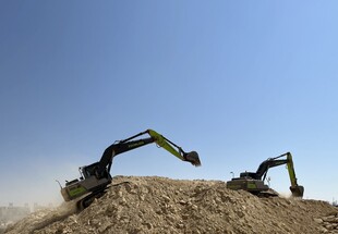两台挖掘机作业于沙堆