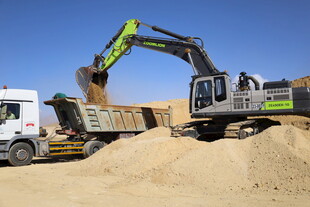 挖掘机向卡车装载沙土