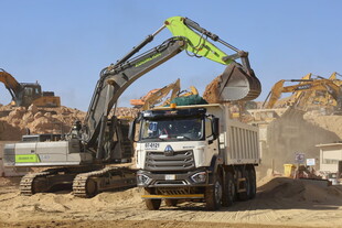 挖掘机向卡车装载砂石