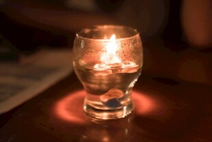 烛光映照下的透明玻璃杯