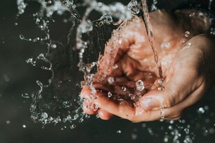 双手捧水溅起晶莹水花