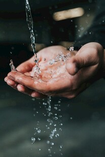 双手捧水溅起晶莹水珠