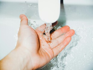 手接水龙头流出的清澈水