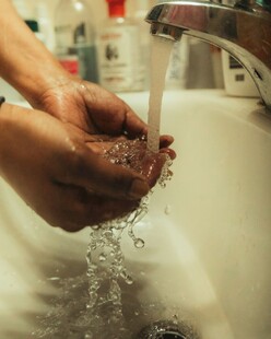 双手在水龙头下清洗泥土