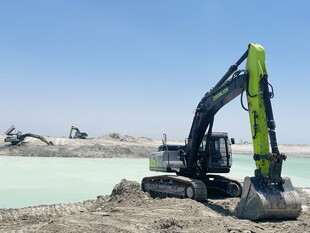 工地中的绿色挖掘机作业