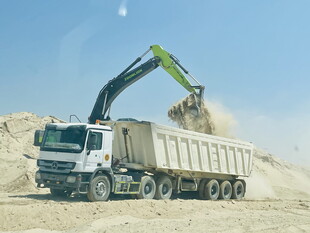 挖掘机向卡车装载沙土
