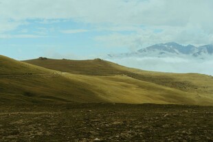 广袤山丘与远处雪山美景