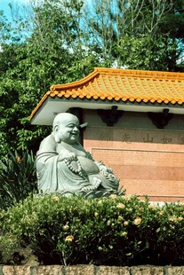 古朴佛像旁的中式建筑