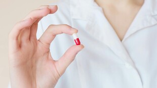 手持胶囊的白衣人物