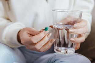 手持药片与水杯准备服药
