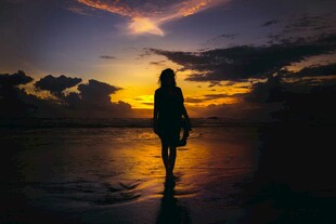 夕阳下独自行走的女子