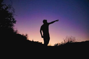黄昏下的指天剪影男子