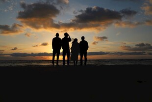 夕阳下的四人海边剪影