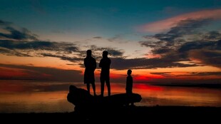 夕阳下的海边友人剪影