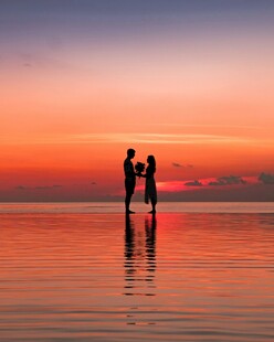 夕阳下情侣在水边浪漫相依