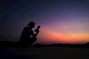 夕阳下摄影师的专注身影