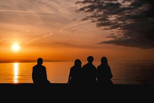 夕阳下的四人海边剪影