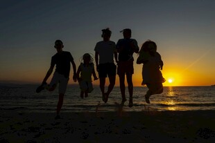 夕阳下海边漫步的人群