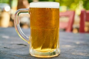 户外木桌上的一杯鲜啤酒