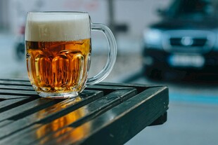 户外木桌上的一杯鲜啤酒