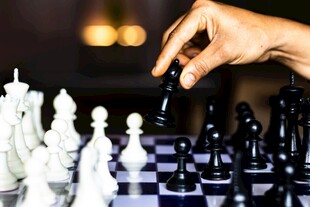 手挪棋子于黑白棋盘间