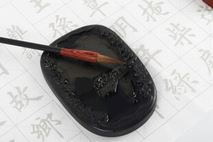 毛笔蘸墨于砚台