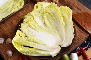 新鲜大白菜摆放在木砧板上