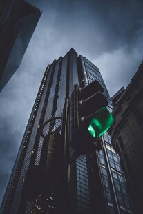 都市高楼间的绿色交通信号灯