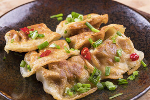 美味煎饺摆放在深色盘中