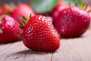 新鲜诱人的草莓摆放在木桌
