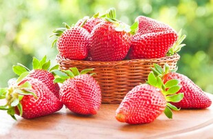 木桌上篮装新鲜红草莓