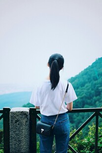 女子凭栏眺望远方美景