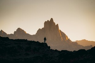夕阳下的孤行者与壮丽山峰
