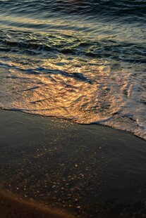 夕阳下的海浪轻拍沙滩