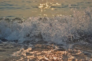 夕阳下的海浪拍打沙滩