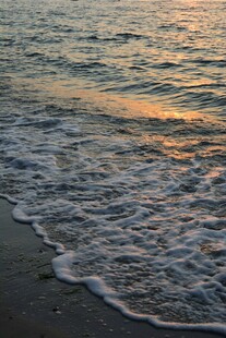 夕阳下的海浪拍打沙滩
