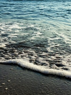 海边浪花拍打黑色沙滩