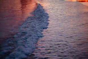 夕阳下海浪拍打沙滩