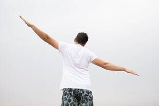 男子舒展双臂拥抱天空