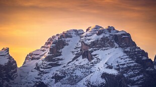 雪覆山峦映夕阳